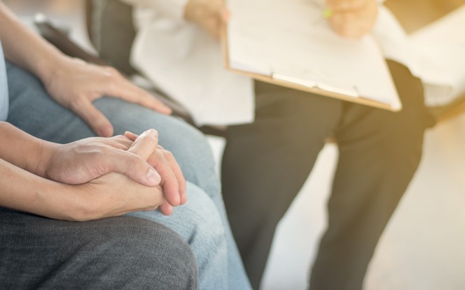 Couple holding hands while talking to someone with a clipboard