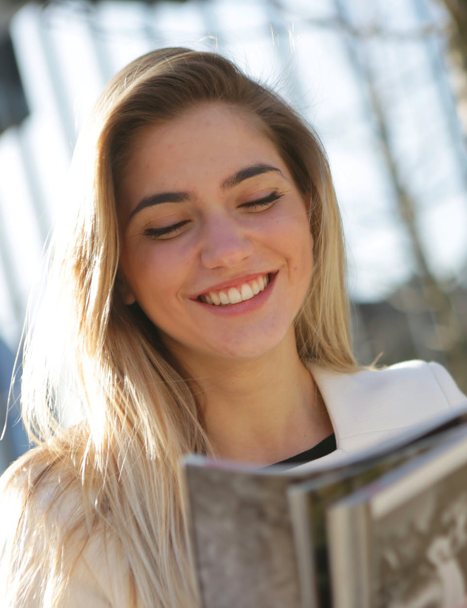 woman holding book and smiling