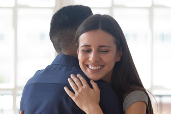 man and woman hugging, smiling